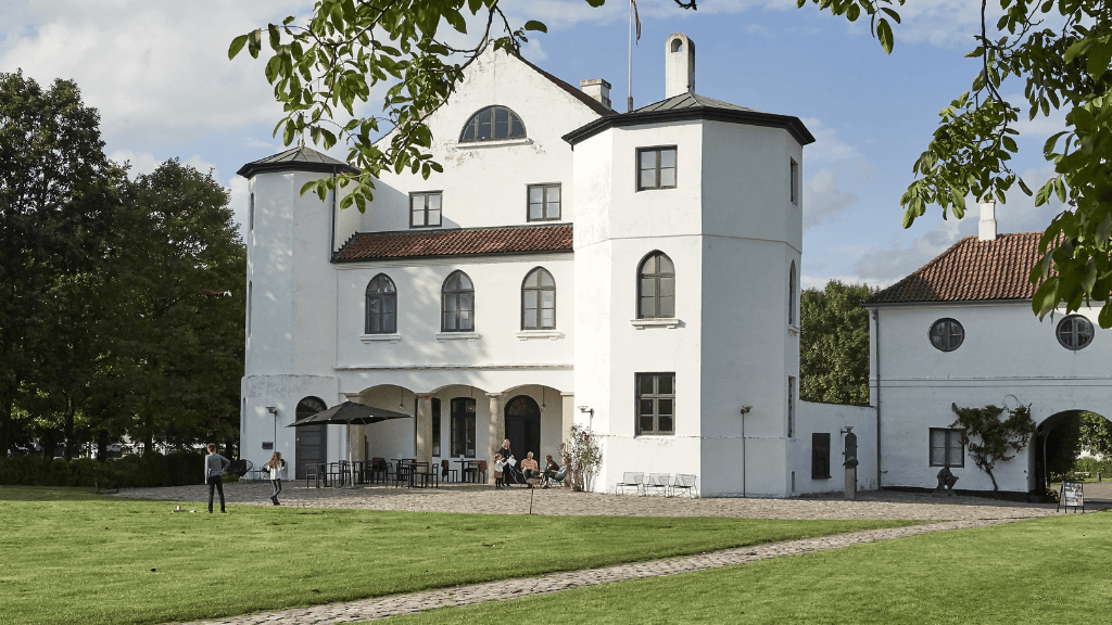 Weisses Schloß fotografiert vom grünen Schloßgarten an einem Sommertag